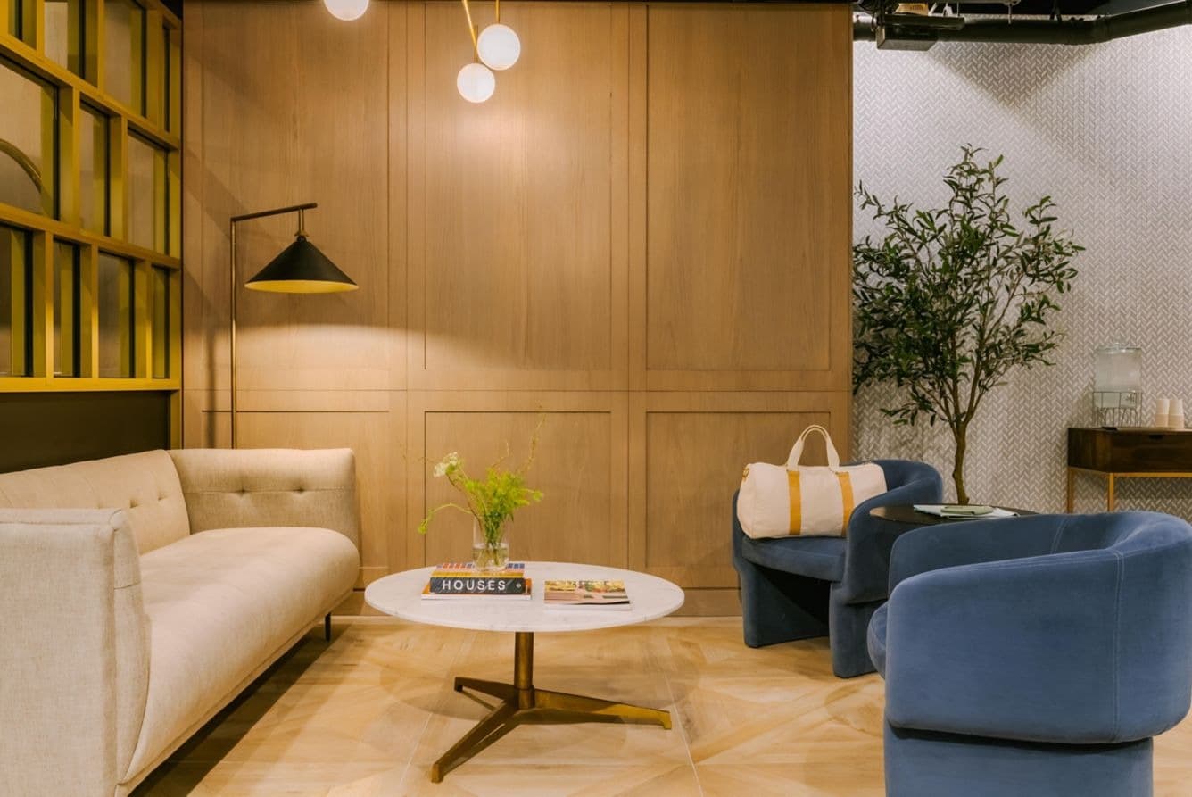 Lobby lounge with blue seating and wood paneling at Nester Finn West Queen West